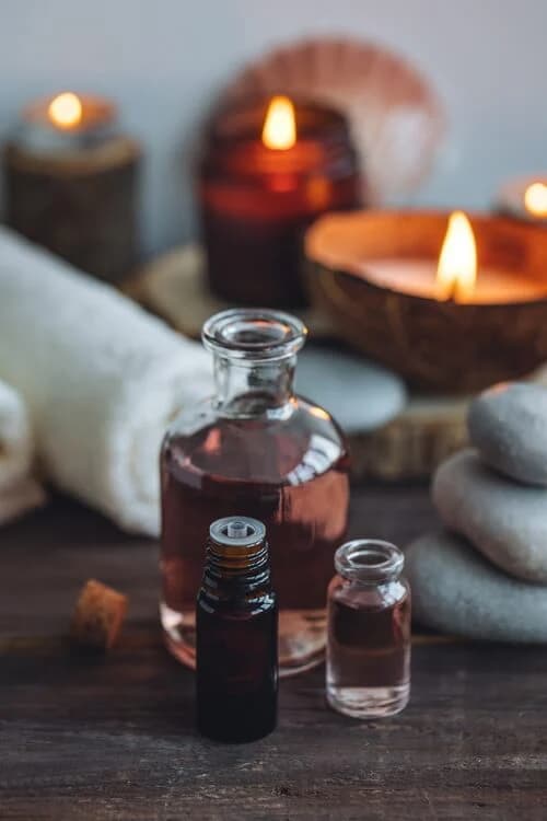 Small aromatic oil bottles beside rolled towels