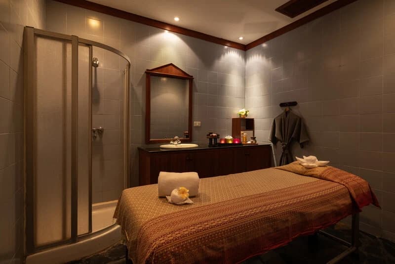 Warmly lit treatment room with a coral-covered massage couch