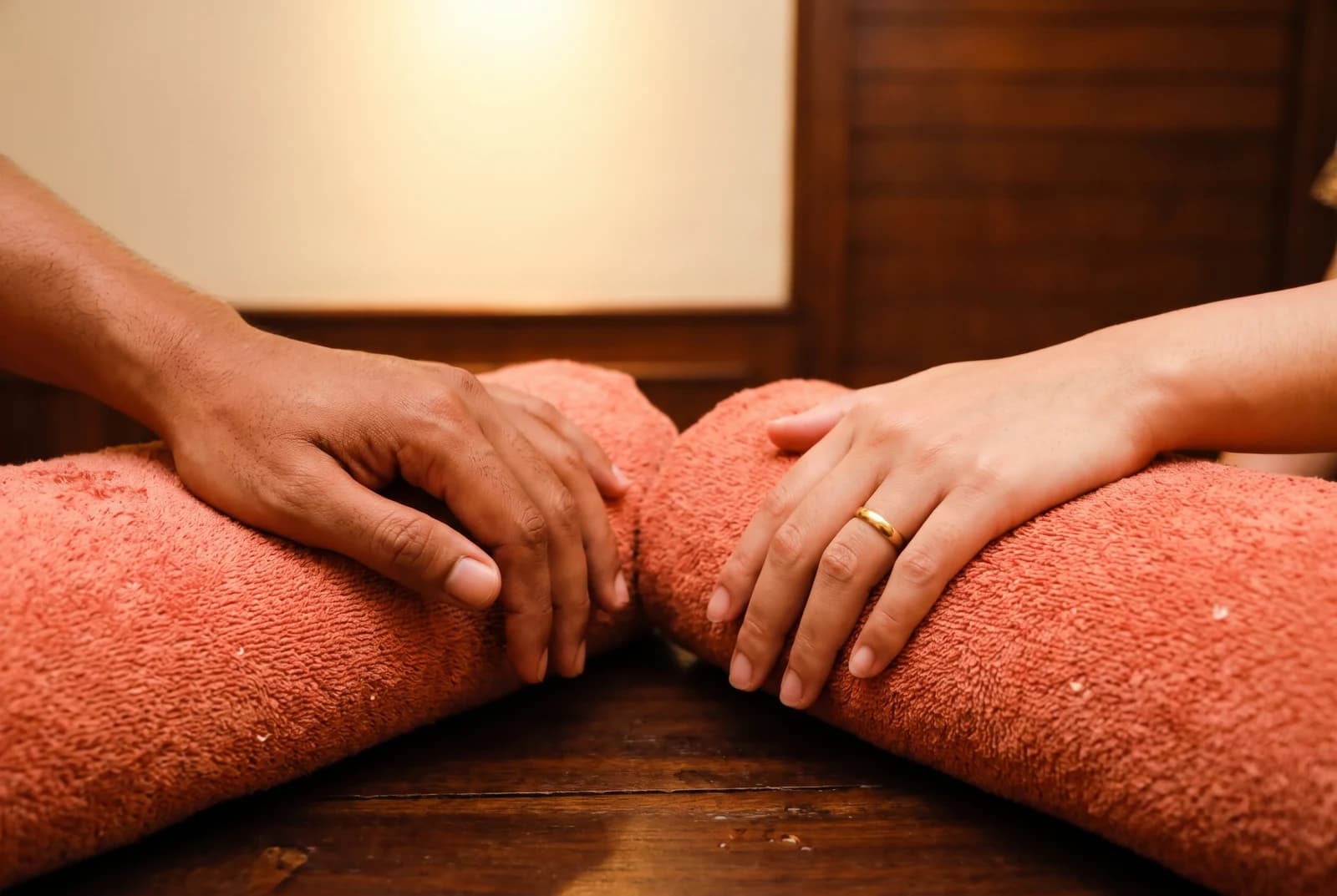 Two guests resting their hands on separate coral towels