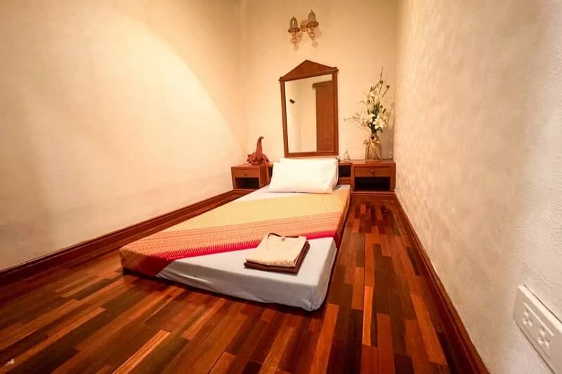 A floor massage mat in a cream-walled treatment room