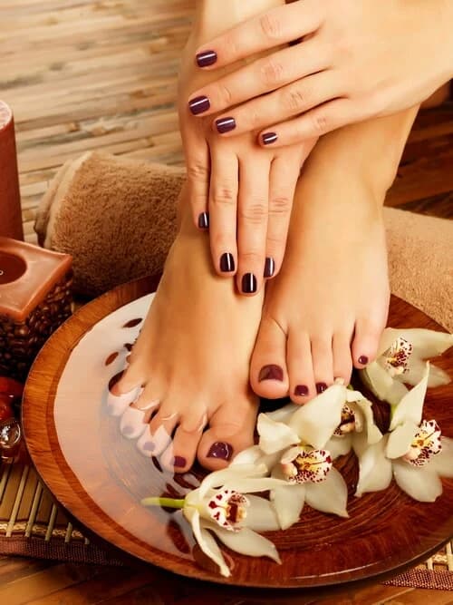 Hands massaging feet above a shallow bowl
