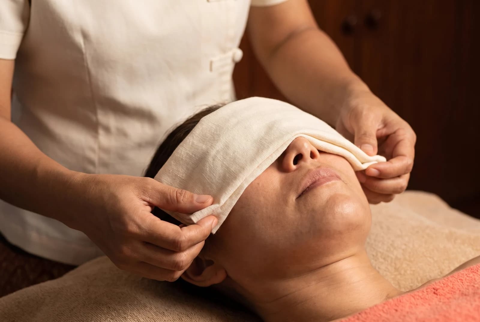 A cloth eye compress gently positioned over closed eyes